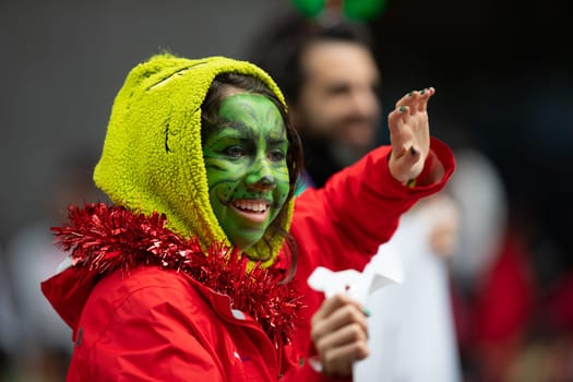 Houston, Texas, USA - November 22, 2018 The H-E-B Thanksgiving Day Parade, Woman dress up as the grinch with face paint, smiling and waving at the spectators
