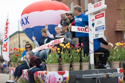 Holland, Michigan, USA - May 12, 2018 Float promoting Re/Max  with a hot air balloon and people holding signs that say, sold, sale pending at the Muziek Parade, during the Tulip Time Festival