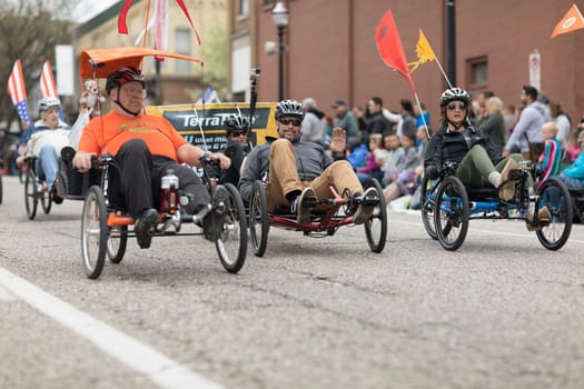Holland, Michigan, USA - May 12, 2018 People riding trikes down the road at the Muziek Parade, during the Tulip Time Festival