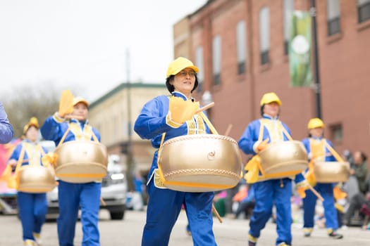 Holland, Michigan, USA - May 12, 2018 Chinese drummers promoting Falun dafa performing at the Muziek Parade, during the Tulip Time Festival