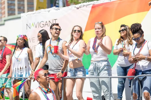 Chicago, Illinois, USA - June 24, 2018: the LGBTQ Pride Parade, Men and women promoting Navigant during the parade
