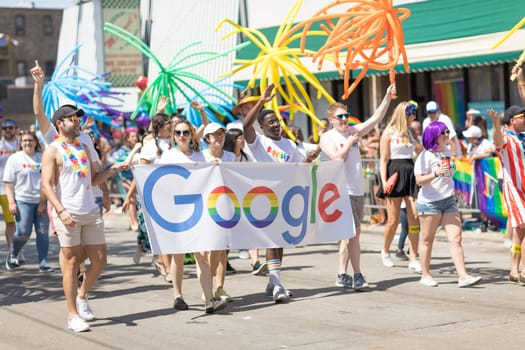 Chicago, Illinois, USA - June 24, 2018: the LGBTQ Pride Parade, People Promoting Google, holding a banner and balloons during the parade