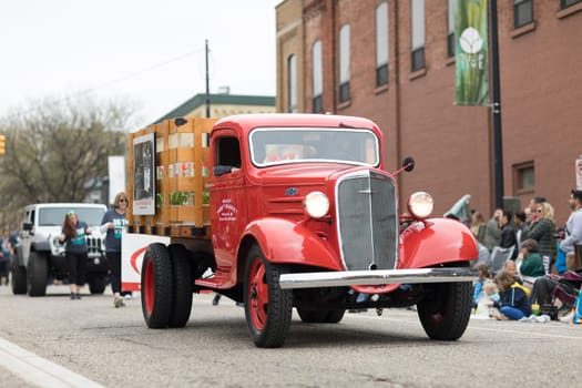 Holland, Michigan, USA - May 12, 2018 An old chevrolet truck, color red with a sign on the dor that say meur's thrift market at the Muziek Parade, during the Tulip Time Festival