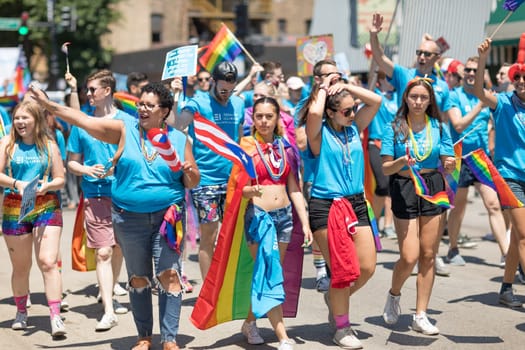 Chicago, Illinois, USA - June 24, 2018 People waving rainbow flags and puerto rican flags celebrating during the LGBTQ Pride Parade in Chicago