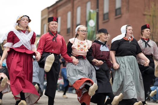 Holland, Michigan, USA - May 12, 2018 A group of young dutch women wearing traditional clothing perform a traditional dance at the Muziek Parade, during the Tulip Time Festival