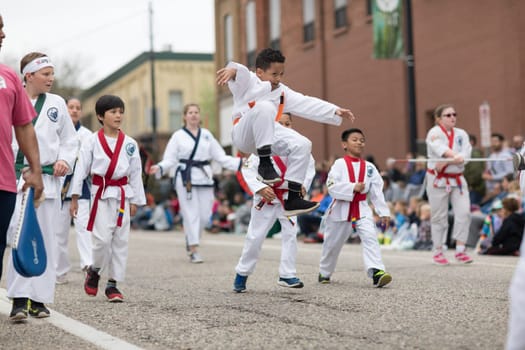 Holland, Michigan, USA - May 12, 2018 Children members of PKSA Karate walk down the road at the Muziek Parade, during the Tulip Time Festival