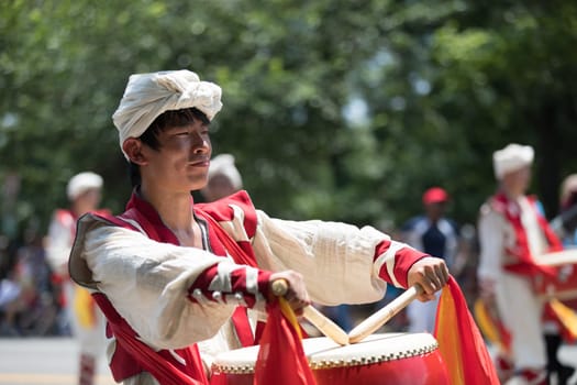 Washington, D.C., USA - July 4, 2018, The National Independence Day Parade, Chinese, wearing traditional clothing, playing drums, going down constitution avenue during the parade