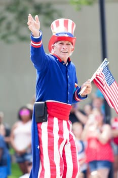 Washington, D.C., USA - July 4, 2018, The National Independence Day Parade, Man dress as Uncle Sam, waving the american flag, going down constitution avenue