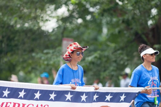 Washington, D.C., USA - July 4, 2018, young man holding a banner and wearing a hat with the colors of the american flag at the National Independence Day Parade