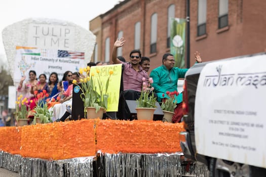 Holland, Michigan, USA - May 12, 2018 People of Indian decent wearing traditional clothing on float going down the street at the Muziek Parade, during the Tulip Time Festival