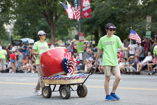 Washington, D.C., USA - July 4, 2018, The National Independence Day Parade, Taiwanese americans, waving american flags and playing a large drum, walking down constitution avenue