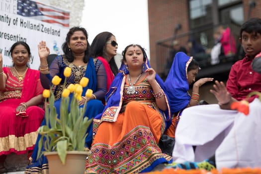 Holland, Michigan, USA - May 12, 2018 People of Indian decent wearing traditional clothing on float going down the street at the Muziek Parade, during the Tulip Time Festival