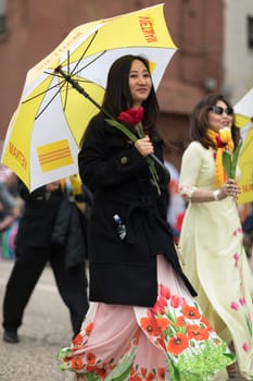 Holland, Michigan, USA - May 12, 2018 Members of Michigan Vietnamese American Community wearing traditional clothing and waving american and vietnamese flags at the Muziek Parade, during the Tulip Time Festival