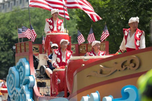 Washington, D.C., USA - July 4, 2018, The National Independence Day Parade, Chinese, wearing traditional clothing, playing drums, and with american flags, going down constitution avenue during the parade