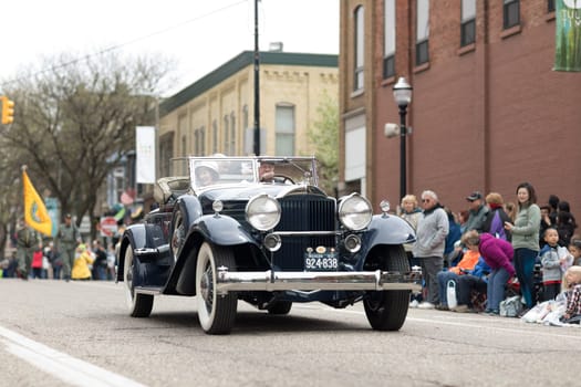 Holland, Michigan, USA - May 12, 2018 People wearing vintage clothing riading a classic car at the Muziek Parade, during the Tulip Time Festival