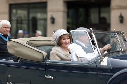 Holland, Michigan, USA - May 12, 2018 People wearing vintage clothing riading a classic car at the Muziek Parade, during the Tulip Time Festival