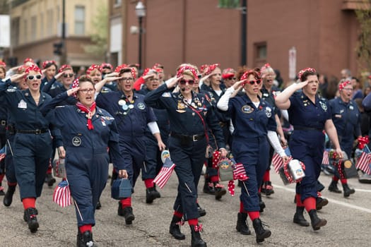 Holland, Michigan, USA - May 12, 2018 Women dress up as Rosie sing and dance at the Muziek Parade, during the Tulip Time Festival