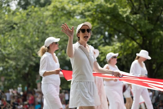 Washington, D.C., USA - July 4, 2018, The National Independence Day Parade, A group of women carrying a giant american flag down constitution avenue