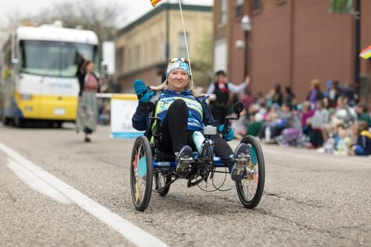 Holland, Michigan, USA - May 12, 2018 Woman riding a trike going down the road at the Muziek Parade, during the Tulip Time Festival