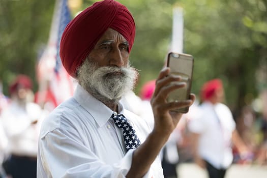 Washington, D.C., USA - July 4, 2018, The National Independence Day Parade, The Sikhs of America, waving american flags, going down constitution avenue during the parade