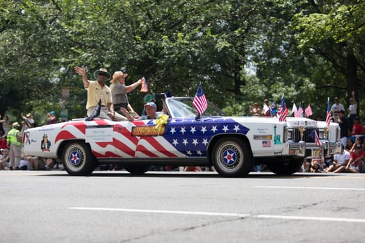 Washington, D.C., USA - July 4, 2018, The National Independence Day Parade, Car carrying flags and painted with the colors of the american flag, going down constitution avenue