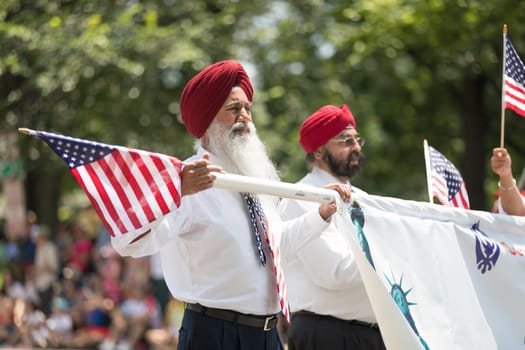 Washington, D.C., USA - July 4, 2018, The National Independence Day Parade, The Sikhs of America, waving american flags, going down constitution avenue during the parade