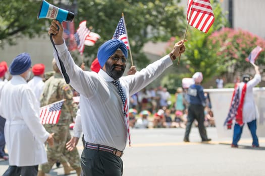Washington, D.C., USA - July 4, 2018, The National Independence Day Parade, The Sikhs of America, waving american flags, going down constitution avenue during the parade