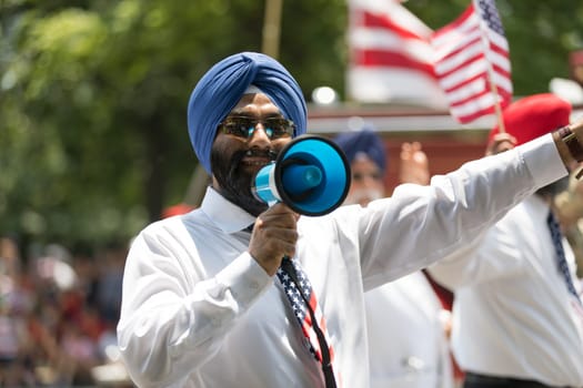 Washington, D.C., USA - July 4, 2018, The National Independence Day Parade, The Sikhs of America, waving american flags, going down constitution avenue during the parade