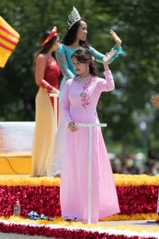 Washington, D.C., USA - July 4, 2018, The National Independence Day Parade, Vietnamese American women wearing traditional dresses, going down constitution avenue