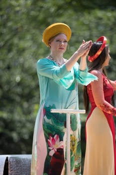Washington, D.C., USA - July 4, 2018, The National Independence Day Parade, Vietnamese American women wearing traditional dresses, going down constitution avenue