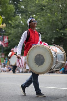 Washington, D.C., USA - July 4, 2018, The National Independence Day Parade, Man playing a large drum while walking down constitution avenue
