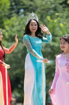 Washington, D.C., USA - July 4, 2018, The National Independence Day Parade, Vietnamese American women wearing traditional dresses, going down constitution avenue