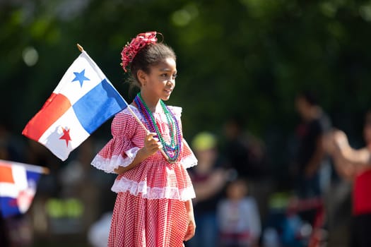 Washington, D.C., USA - September 29, 2018: The Fiesta DC Parade, Girl wearing traditional clothing from Panama holding the panamanian flag.