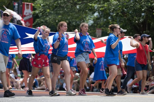 Washington, D.C., USA - July 4, 2018, The National Independence Day Parade, The National Independence Day Volunteers carrying flags down constitution avenue