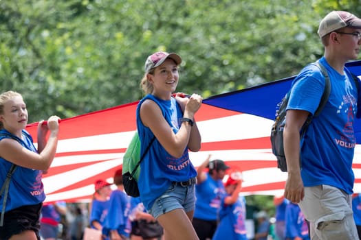 Washington, D.C., USA - July 4, 2018, The National Independence Day Parade, The National Independence Day Volunteers carrying flags down constitution avenue