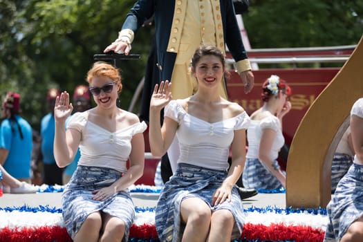 Washington, D.C., USA - July 4, 2018, The National Independence Day Parade, Young women wearing retro outfits, on a float, going down constitution avenue
