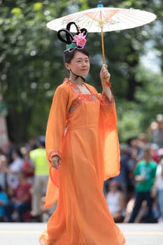 Washington, D.C., USA - July 4, 2018, The National Independence Day Parade, Chinese Women wearing traditional chinese clothing, going down constitution avenue