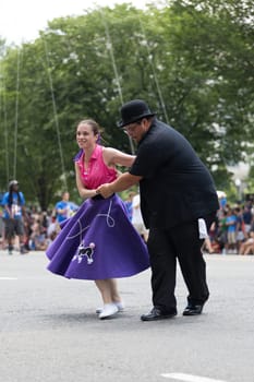Washington, D.C., USA - July 4, 2018, The National Independence Day Parade, The Gottaswing Dancers, with outfits from the 60s, going down constitution avenue