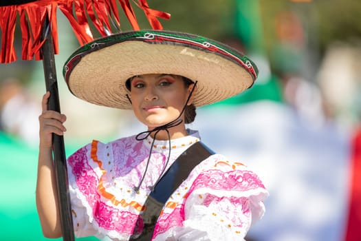 Washington, D.C., USA - September 29, 2018: The Fiesta DC Parade, Woman wearing traditional clothing from Mexico carrying a banner