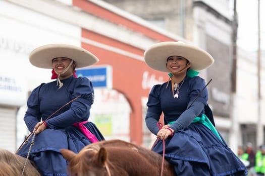 Matamoros, Tamaulipas, Mexico - November 20, 2018: The November 20 Parade, women wearing traditional mexican clothing riding horses during the parade