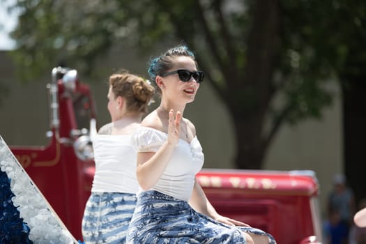 Washington, D.C., USA - July 4, 2018, The National Independence Day Parade, Young women wearing retro outfits, on a float, going down constitution avenue