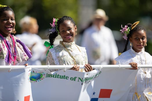Washington, D.C., USA - September 29, 2018: The Fiesta DC Parade, Young women wearing traditional clothing from panama carrying a banner promoting the Institute of National Dance