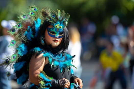 Washington, D.C., USA - September 29, 2018: The Fiesta DC Parade, Men and women from guatemala wearing traditional clothing representing the Indigenous peoples of guatemala wearing abstract mask in shape of a female face with feathers