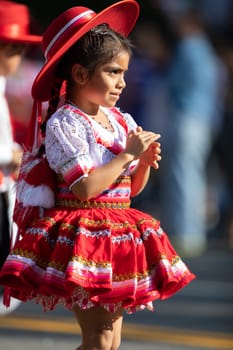 Washington, D.C., USA - September 29, 2018: The Fiesta DC Parade, Young Bolivian girl wearing traditional clothing going down the street during the parade