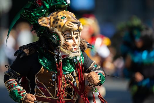 Washington, D.C., USA - September 29, 2018: The Fiesta DC Parade, Men and women from guatemala wearing traditional clothing representing the Indigenous peoples of guatemala wearing abstract mask in shape of a female face with a tiger helmet