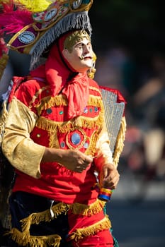 Washington, D.C., USA - September 29, 2018: The Fiesta DC Parade, Men and women from guatemala wearing traditional clothing representing the Indigenous peoples of guatemala wearing abstract mask in shape of a man's face