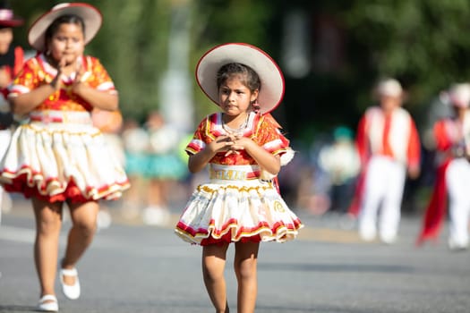 Washington, D.C., USA - September 29, 2018: The Fiesta DC Parade, Young Bolivian girl wearing traditional clothing going down the street during the parade