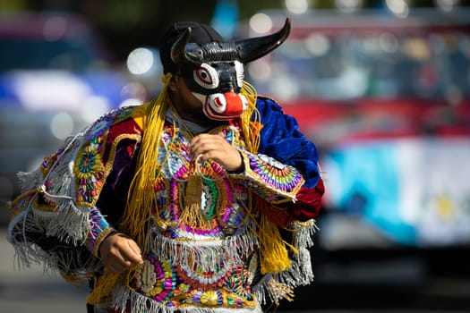 Washington, D.C., USA - September 29, 2018: The Fiesta DC Parade, Men and women from guatemala wearing traditional clothing representing the Indigenous peoples of guatemala wearing abstract mask in shape of a bull