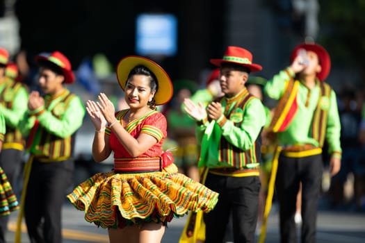 Washington, D.C., USA - September 29, 2018: The Fiesta DC Parade, Young woman and men wearing traditional bolivian clothing dancing