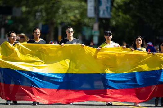 Washington, D.C., USA - September 29, 2018: The Fiesta DC Parade, Men and women carry a giant colombian flag